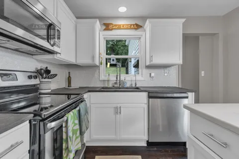 a kitchen with stainless steel appliances granite countertop a sink stove and cabinets