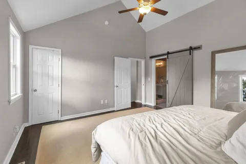 a spacious bedroom with a bed and a chandelier