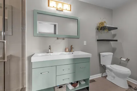 a bathroom with a toilet sink and mirror