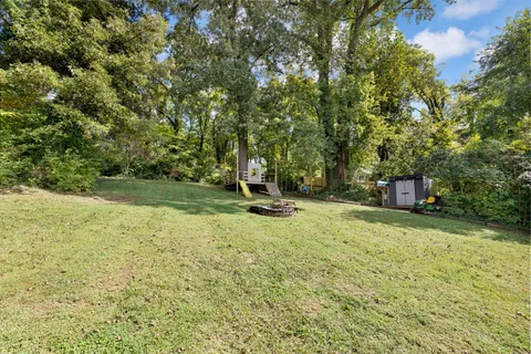 a view of a house with a big yard and large trees