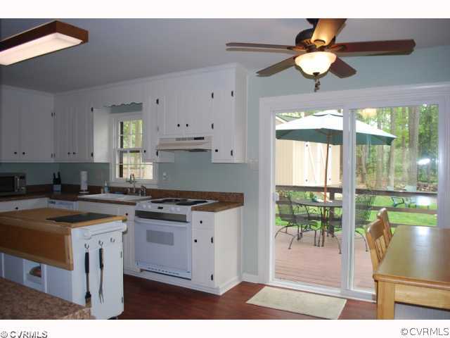 11121 Alanthus Road Midlothian, VA 23112 - Photo 3 of 12 a kitchen with stainless steel appliances granite countertop a stove a refrigerator a sink a dining table and chairs with wooden floor