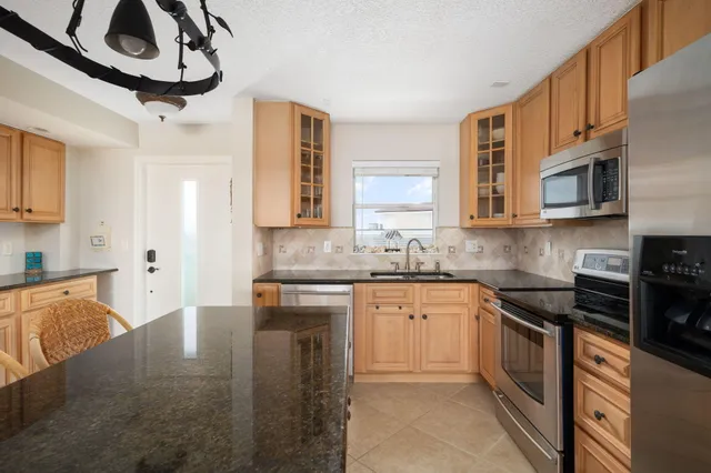 a kitchen with stainless steel appliances granite countertop a stove sink microwave and cabinets
