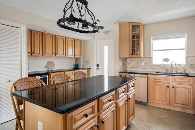 a kitchen with stainless steel appliances granite countertop a sink a stove cabinets counter space and a window
