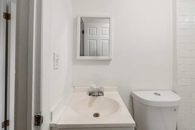 a bathroom with a sink a toilet and mirror