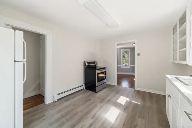 a view of a kitchen with a refrigerator a stove top oven and cabinets