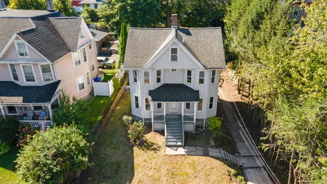 aerial view of a house with a yard and large tree
