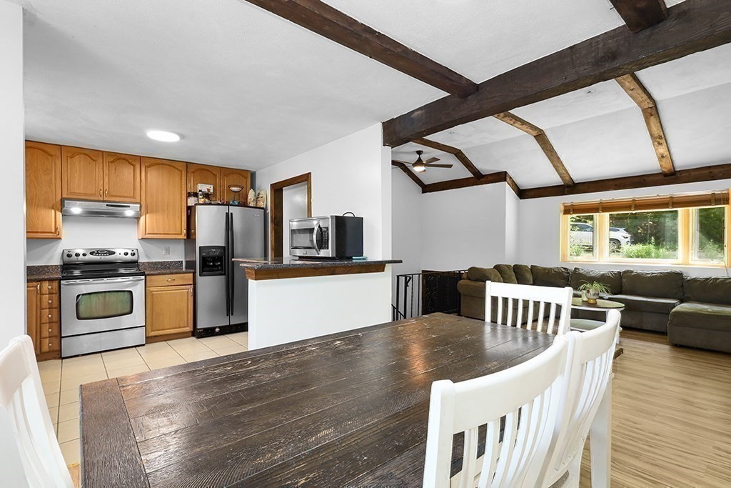 163 Walnut Road Wrentham, MA 02093 - Photo 6 of 39 a kitchen with stainless steel appliances granite countertop a refrigerator a stove top oven a sink dishwasher and white cabinets with wooden floor