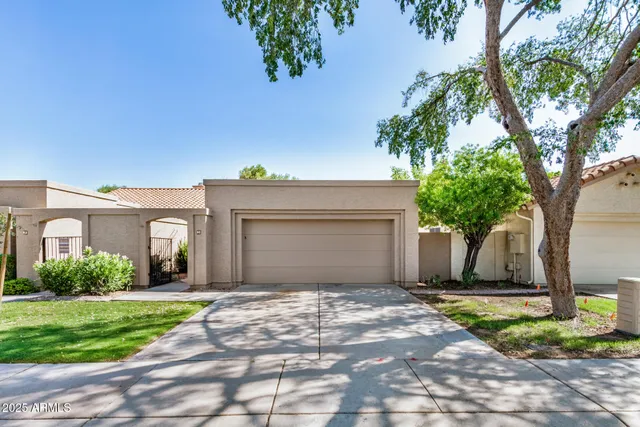 a front view of a house with a garden and trees