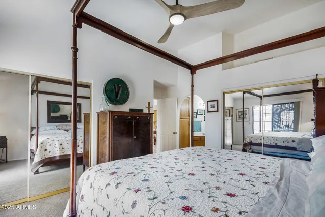 a bedroom with a bed and a large mirror on the dresser