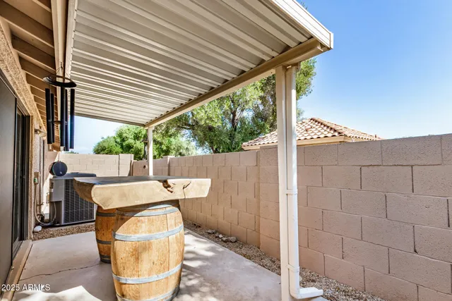 a patio with table and chairs and potted plants