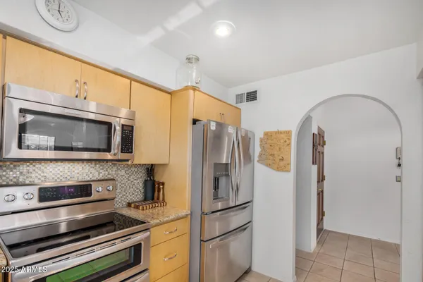 a kitchen with stainless steel appliances a refrigerator stove and microwave