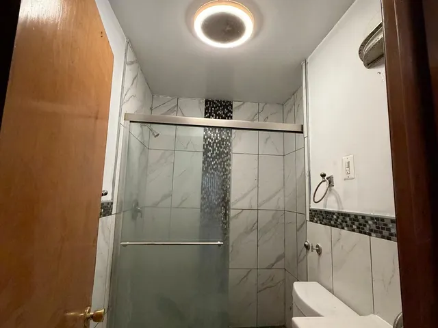a bathroom with a toilet and a shower