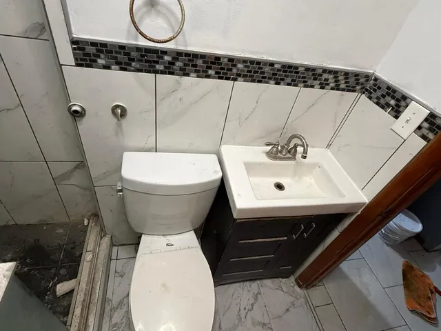 a bathroom with a sink toilet and mirror