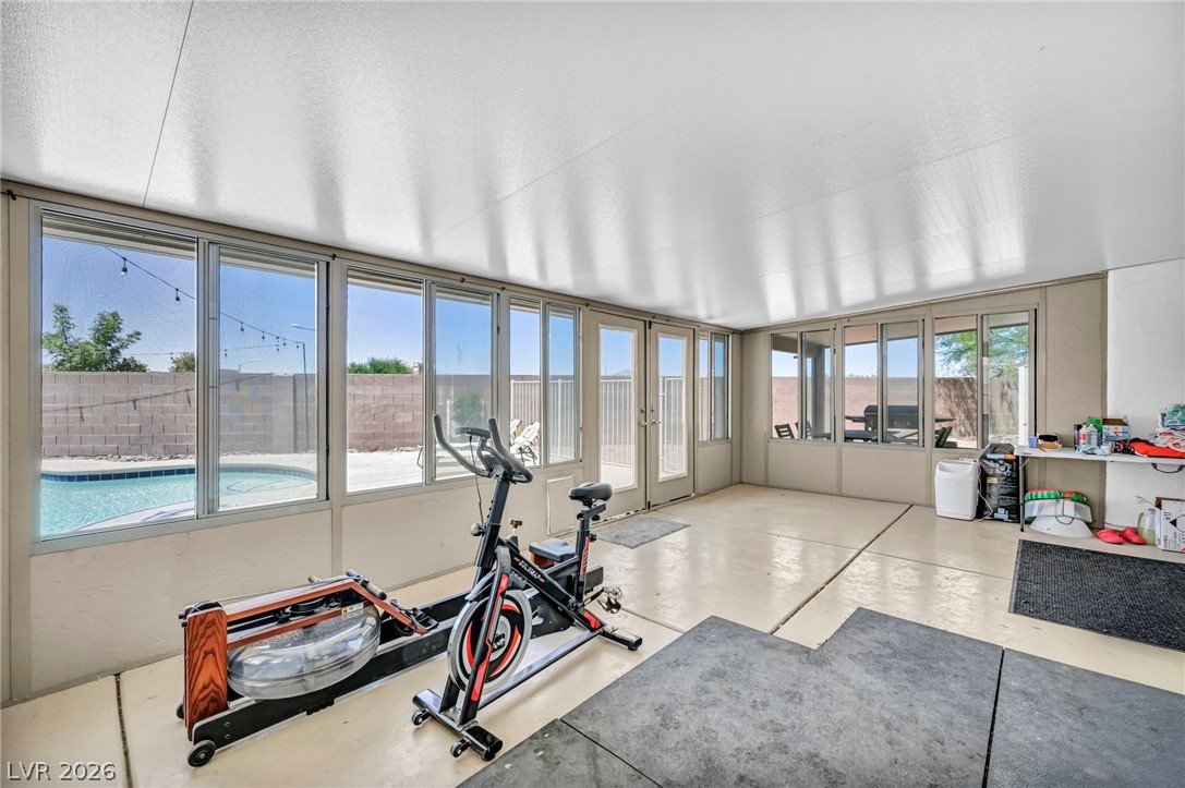 1234 Sunfire Street Henderson, NV 89014 - Photo 22 of 40 A well-lit sunroom with ample windows offers a serene view of the private swimming pool.