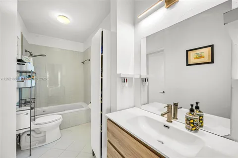 a bathroom with a sink mirror toilet and bathtub