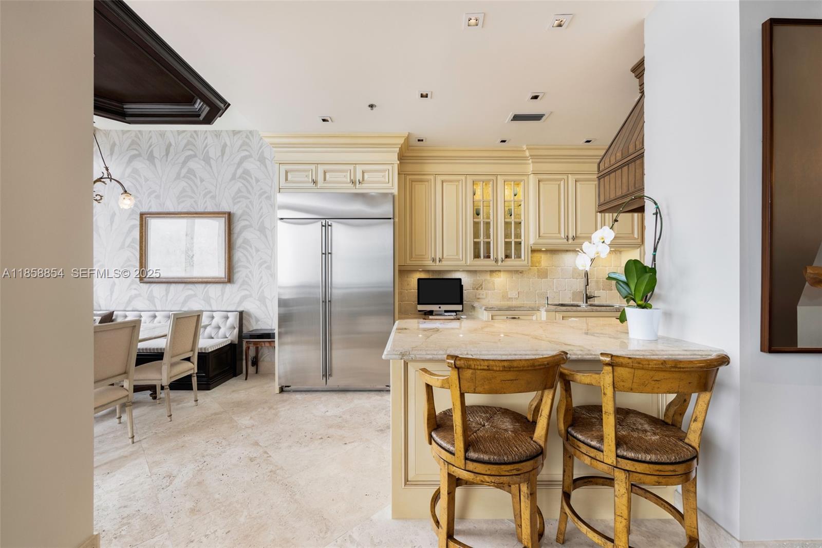 1581 Brickell Avenue, Unit T104 Miami, FL 33129 - Photo 9 of 42 a kitchen with stainless steel appliances kitchen island granite countertop a table and chairs in it
