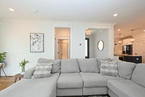 a large kitchen with stainless steel appliances kitchen island granite countertop a sink a stove a refrigerator and white cabinets