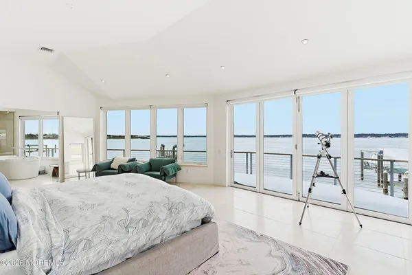 a large bedroom with a large bed and a view of living room