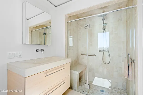 a bathroom with a granite countertop sink a mirror a vanity and shower