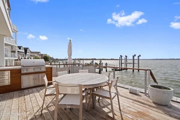 a view of a roof deck with dining table and chairs