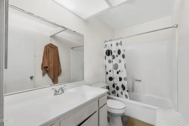 a bathroom with a sink a toilet and shower curtain