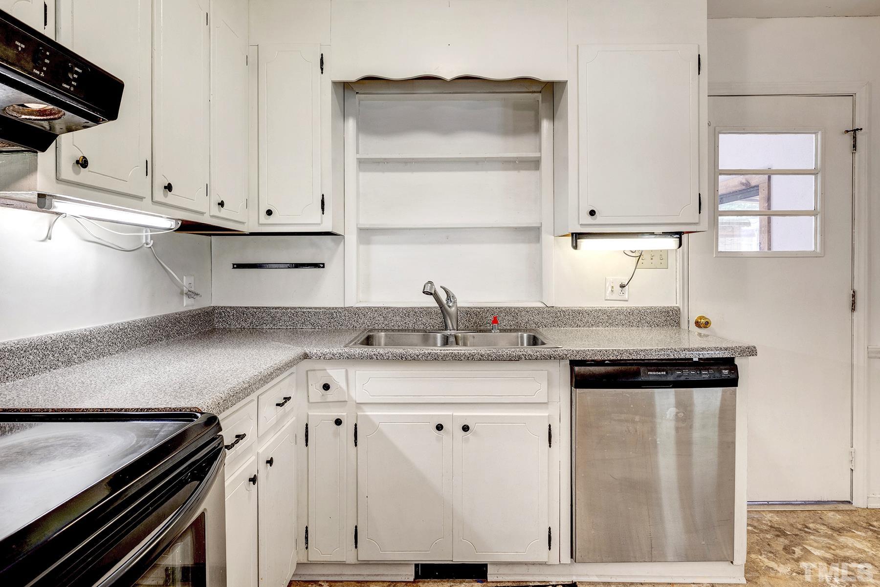 5816 Neuse Street Raleigh, NC 27610 - Photo 6 of 32 a kitchen with granite countertop a sink cabinets and stainless steel appliances