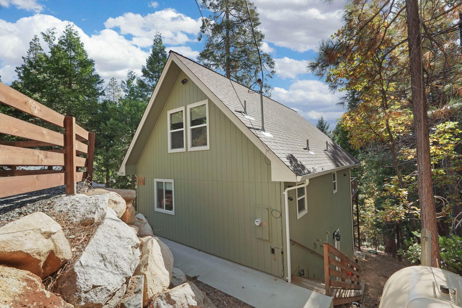 20819 Muheli Road Mi Wuk Village, CA 95346 - Photo 11 of 49 a backyard of a house with large trees and outdoor seating