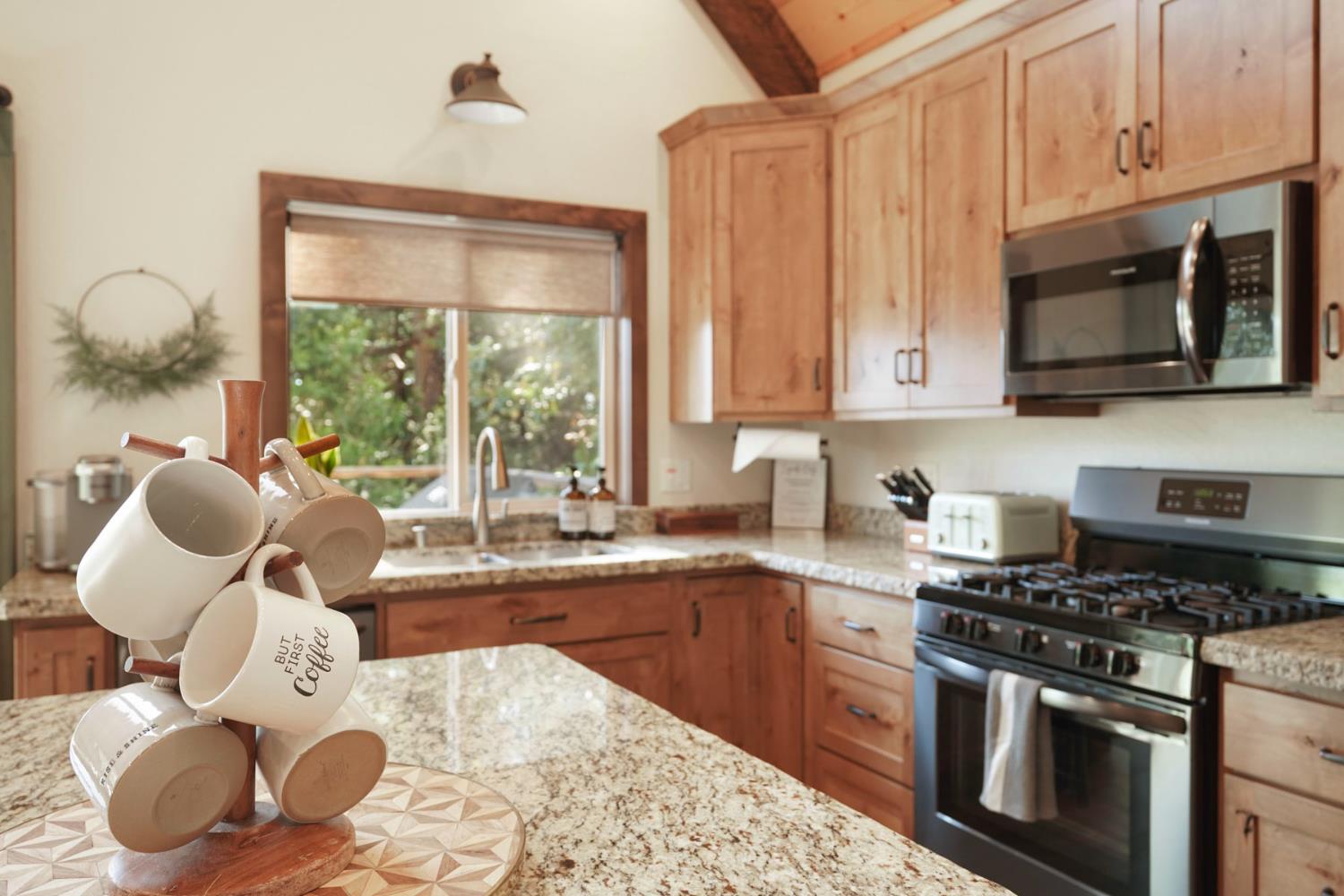 20819 Muheli Road Mi Wuk Village, CA 95346 - Photo 22 of 49 a kitchen with a stove a sink and a microwave