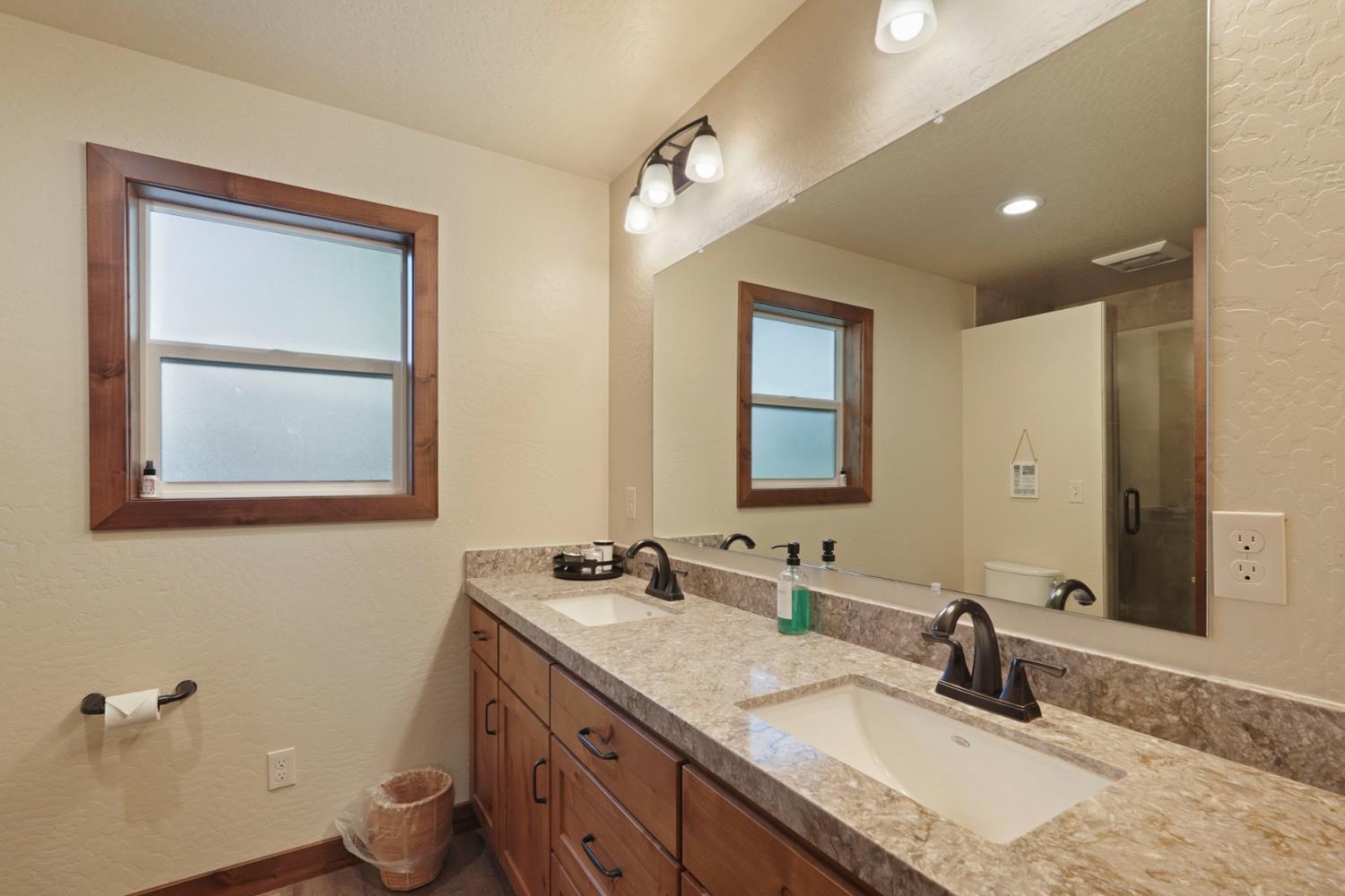 20819 Muheli Road Mi Wuk Village, CA 95346 - Photo 30 of 49 a bathroom with a granite countertop sink mirror and vanity