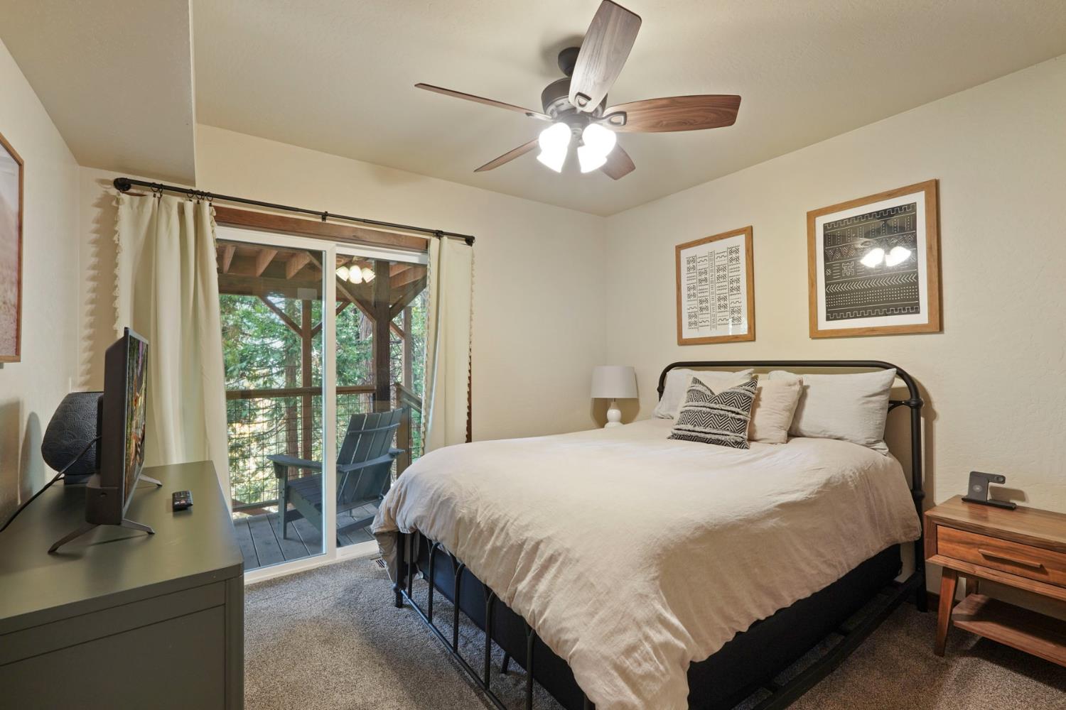 20819 Muheli Road Mi Wuk Village, CA 95346 - Photo 41 of 49 a bedroom with a bed wooden floor and a large window