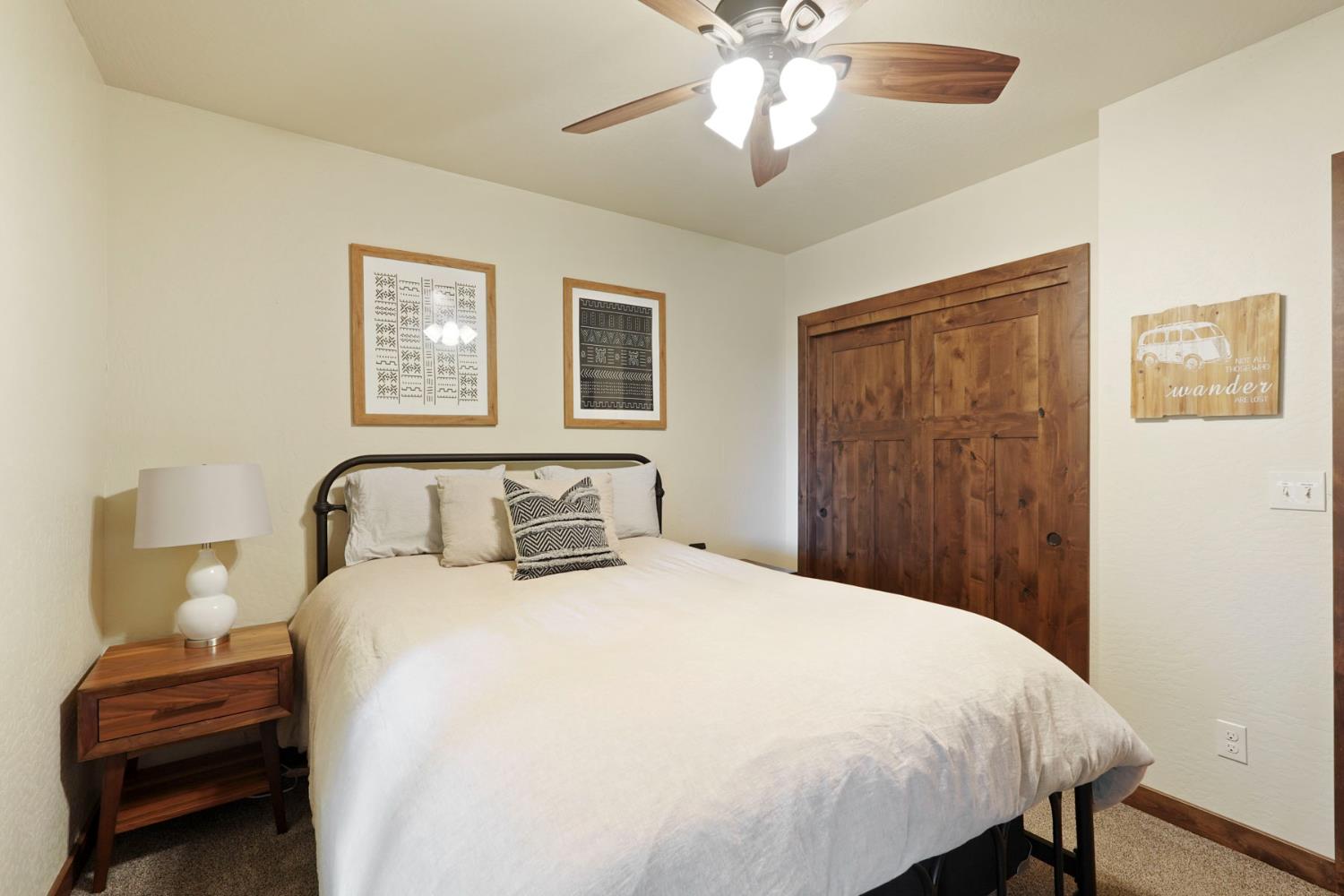 20819 Muheli Road Mi Wuk Village, CA 95346 - Photo 42 of 49 a bedroom with a large bed and a chandelier