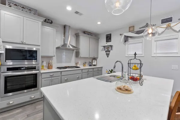 a kitchen with stainless steel appliances granite countertop a sink and a stove