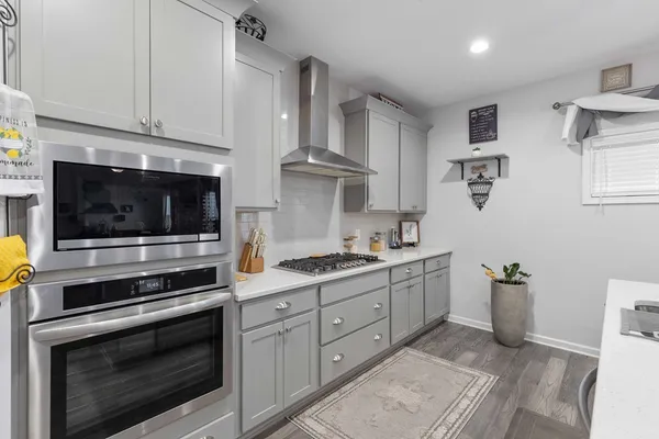 a kitchen with stainless steel appliances white cabinets and stove top oven