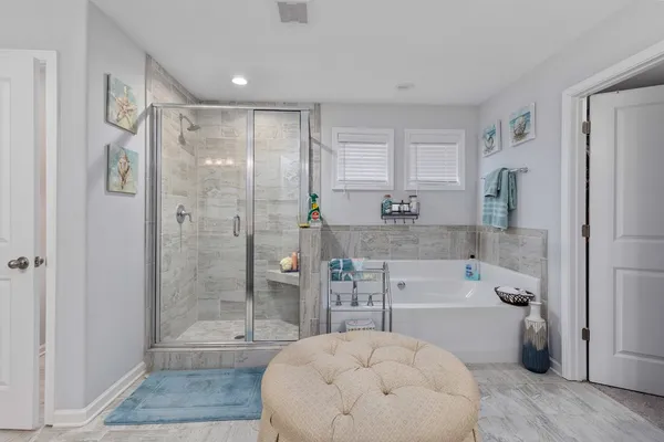 a bathroom with a tub shower sink and mirror