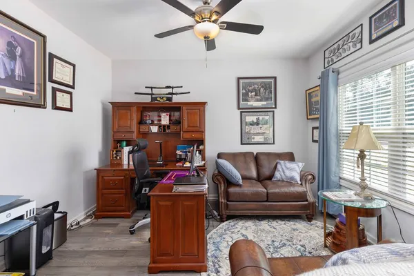 a living room with furniture ceiling fan and a window