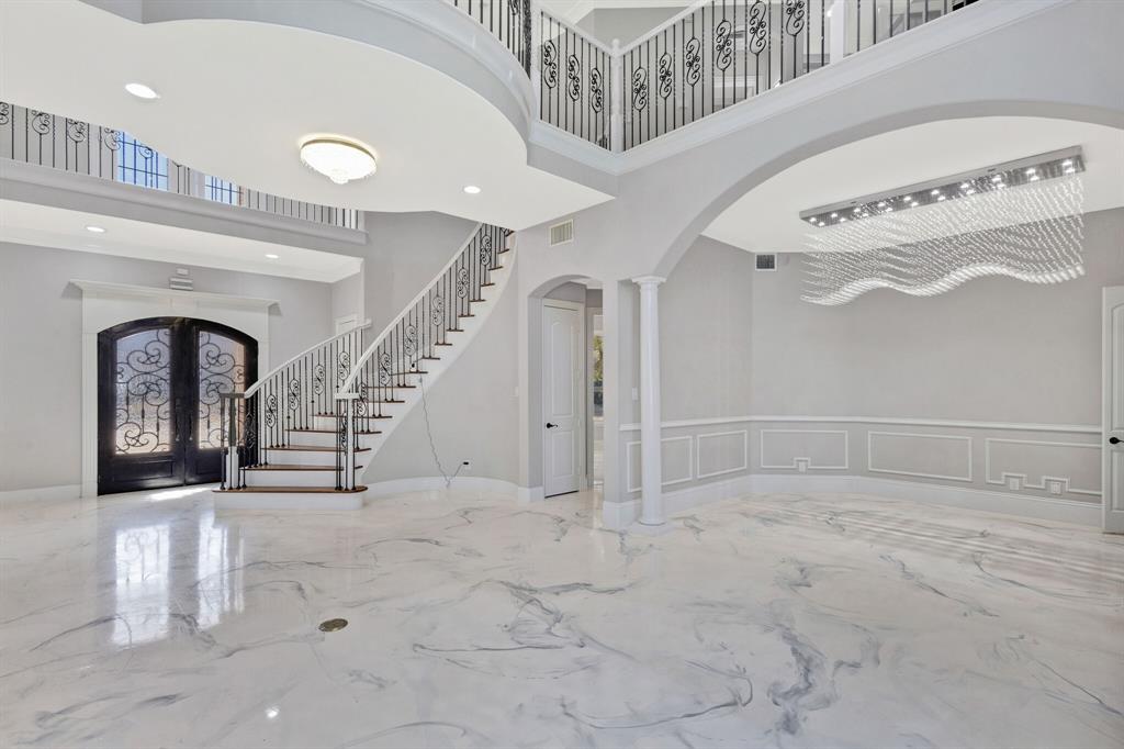 1004 Drake Drive Euless, TX 76039 - Photo 17 of 39 Grand foyer featuring sweeping curved stairs with decorative wrought iron railing creating a dramatic entry.