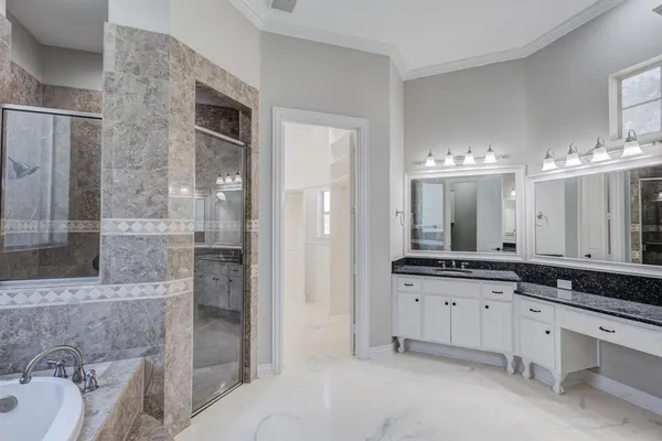 a spacious bathroom with a granite countertop sink mirror and shower