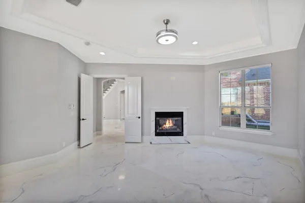 a view of an empty room with a fireplace and a window