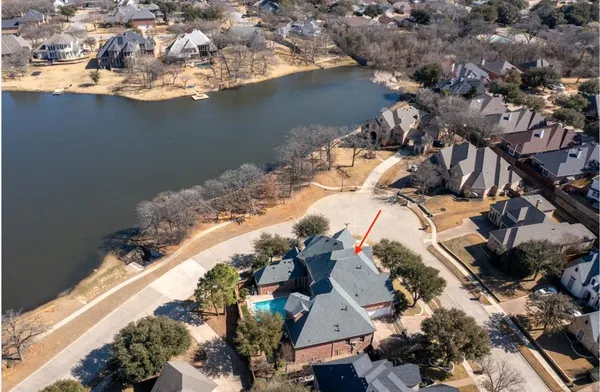 an aerial view of a house with a lake