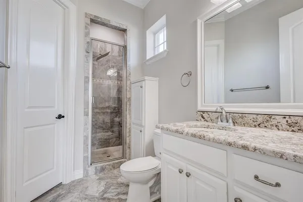 a bathroom with a granite countertop sink toilet and shower