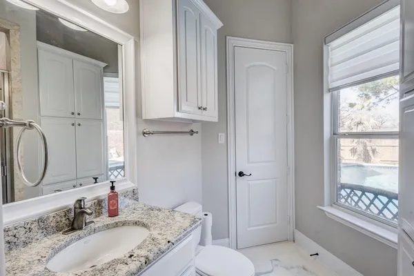 a bathroom with a granite countertop sink toilet and shower