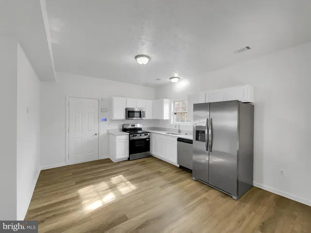 a kitchen with a refrigerator and a stove top oven