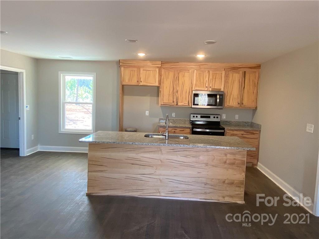 3765-l L L L Davis Road Clover, SC 29710 - Photo 5 of 13 a kitchen with kitchen island granite countertop a stove top oven a sink and a granite counter top