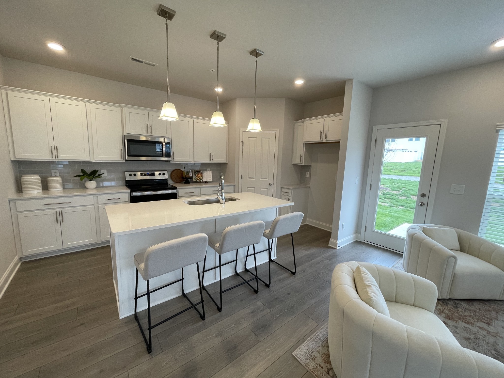 a kitchen with kitchen island a white counter top space a sink stainless steel appliances and cabinets