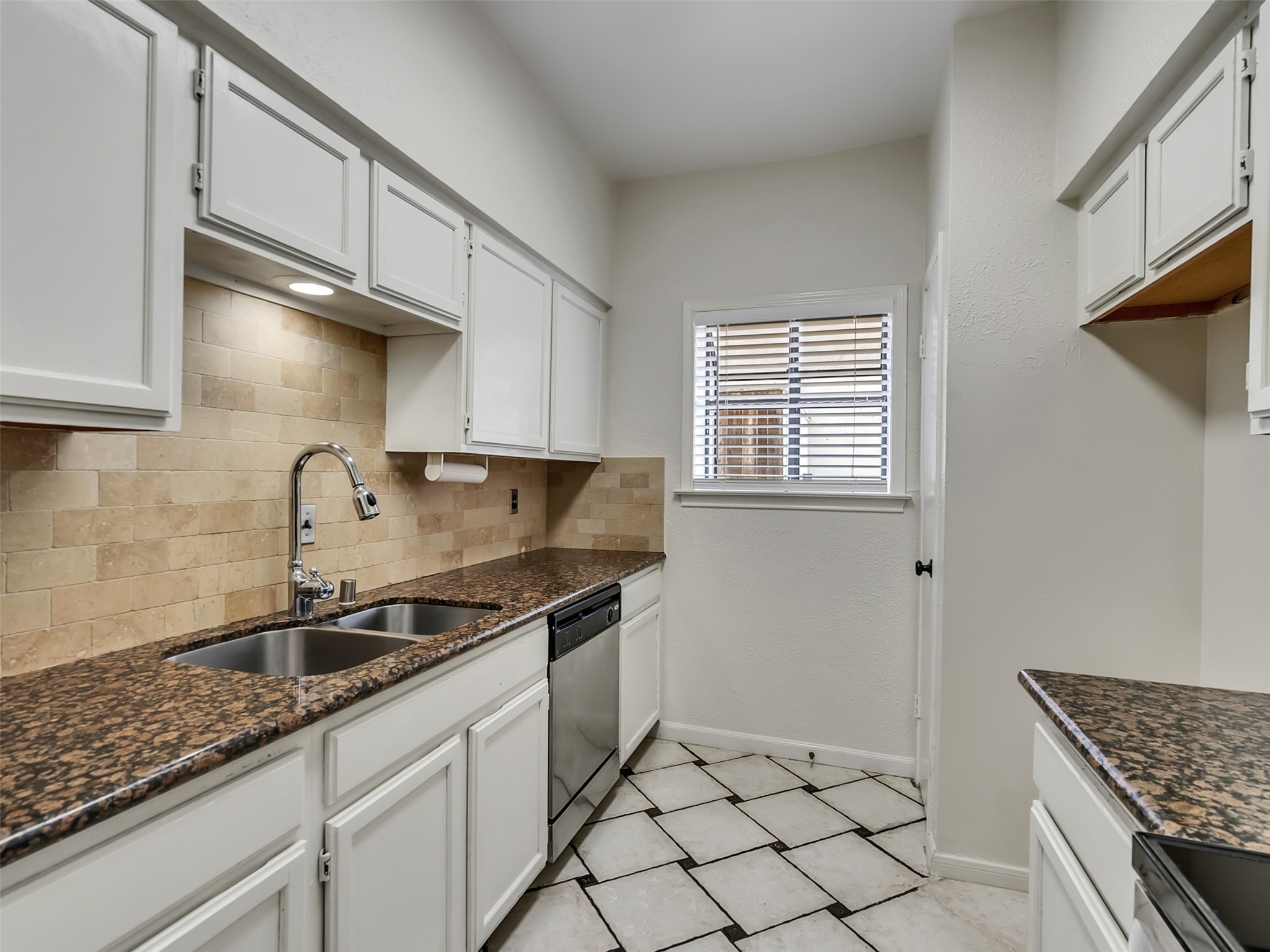 4001 Tanglewilde Street, Unit 605 Houston, TX 77063 - Photo 11 of 29 a kitchen with granite countertop a sink and cabinets