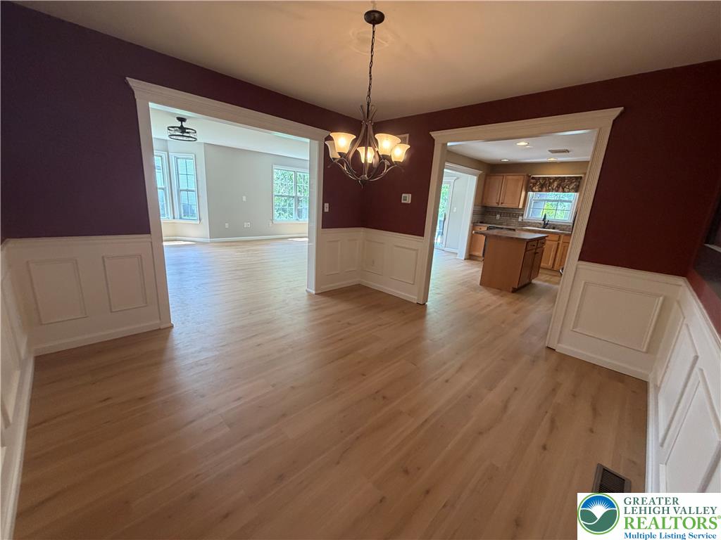 4157 Walter Road Bethlehem, PA 18020 - Photo 14 of 36 Natural light illuminates the hardwood flooring, guiding you through an open layout connecting dining and kitchen spaces.