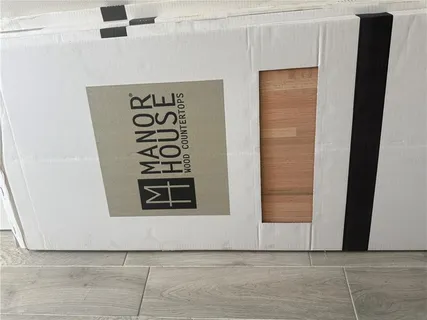 a view of a hallway with wooden floor and a bathroom