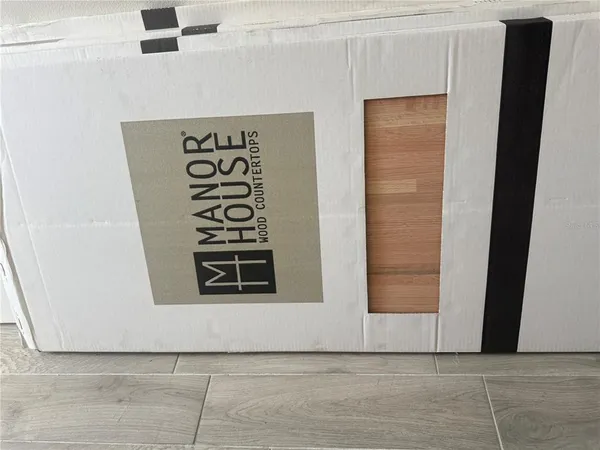 a view of a hallway with wooden floor and a bathroom