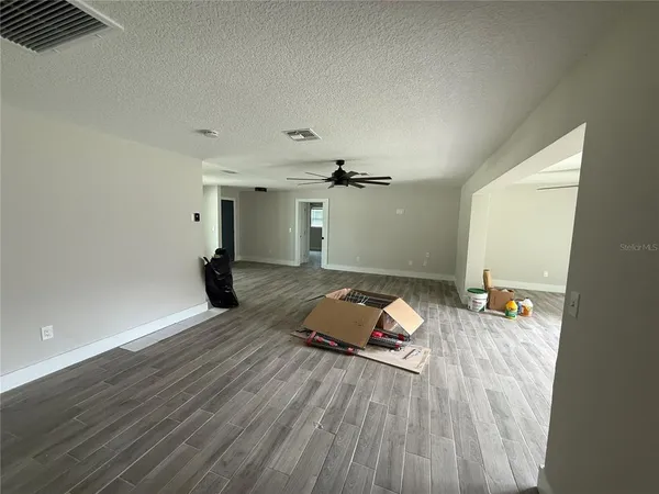 a view of cabinets with stainless steel appliances wooden floor and window