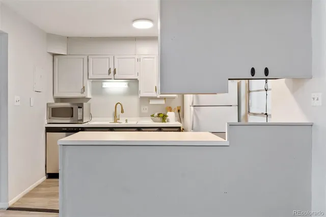 a kitchen with stainless steel appliances a sink stove and white cabinets